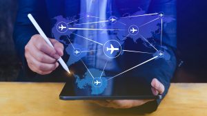 Business professional using digital tablet with global flight network map, symbolizing aviation supply chain, logistics, and Supplier Relationship Management.