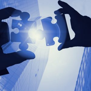  Hands connecting puzzle pieces symbolizing strategic partnerships, collaboration, and Supplier Relationship Management in modern business.