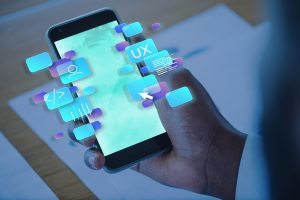 Person using a smartphone with floating UX and UI design icons, representing digital innovation, user experience, and technology integration